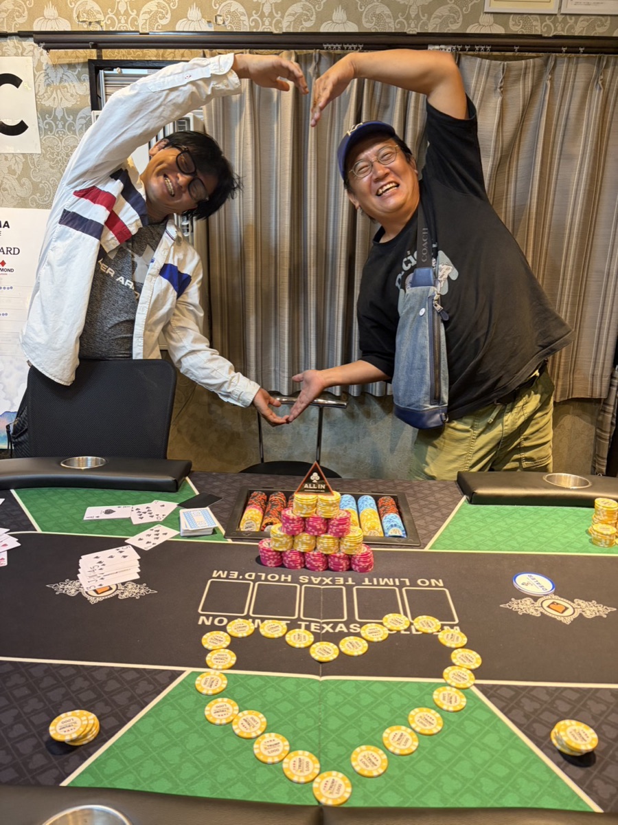 テーブルの前で2人のお客さまが腕でハートを作り、チップもハートの形に並べている様子